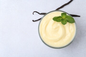 Wall Mural - tasty vanilla pudding, mint and pods on light grey table, top view. space for text