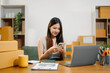 © Nuttapong punna - Startup small business SME, Entrepreneur owner woman using smartphone or tablet taking receive