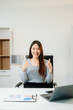 © Nuttapong punna - Asian woman sitting at a desk using a laptop computer Navigating Finance and Marketing