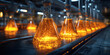 © Jibber  - Produktionslinie mit leuchtend orangefarbenen Chemikalien in Kolbenflaschen