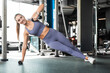 © ty - Muscular sport woman doing side plank at gym.