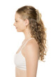 © vladimirfloyd - Side profile of young woman with wavy hair partially secured with beige hair claw clip, wearing white tank top against clean background, showing natural beauty