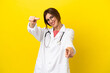 © luismolinero - Doctor woman isolated on yellow background points finger at you while smiling