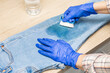 © Oleg Opryshko - man cleaning jeans from dirt with a brush. woman removing dirty stain on jeans, close-up. dirty stain on jeans. man removes grease stain from clothes.