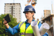 © Iryna - Portrait of female Construction manager reviewing plans on site while overseeing building development project