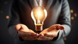 © Joann - hands holding glowing lightbulb innovation and business idea