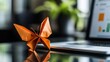 © win - Creative workspace with origami butterfly and laptop displaying graphic charts
