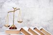 © lana_u - Law concept - Open law book, Judge's gavel, scales, Themis statue on table in a courtroom or law enforcement office. Wooden table, gray concrete background.