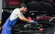 © Ann Rodchua - Portrait Adult Professional handsome male mechanic wearing uniform, fix, repair, check, inspect car engine, standing in automobile maintenance service center or shop.