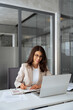 © Stock 4 You - Vertical portrait latin hispanic woman using laptop computer for business studying having videocall with online virtual webinar training meeting, writing notes. Focused businesswoman working in office