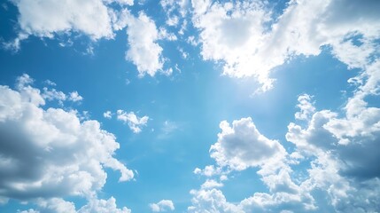 Wall Mural - bright and fluffy clouds floating across a clear sky during a sunny day promoting a feeling of peace