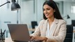 © Qbertstudio - Indian businesswoman typing on laptop at desk in office. Shows professional at work in modern location, promoting career, technology, and diversity.