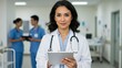 © Qbertstudio - Hispanic doctor with tablet in hospital. Medical professional using technology. Diverse healthcare team provides patient care, demonstrates innovation, expertise and teamwork.