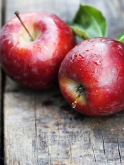 Poster - Two fresh red apples with droplets on rustic wooden table for healthy eating and snacks : Generative AI