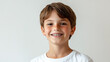 © Roman P. - Young boy with braces smiles confidently. He has brown hair and a white t-shirt with a bright white background.