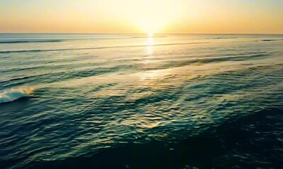 Wall Mural - calm ocean backdrop with a golden sunset on the horizon, soft waves reflecting the warm hues of the 