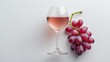 © AbstractAI - Glass of rosÃ© wine and grapes isolated on a white background viewed from above.
