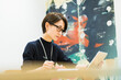 © One - オフィスで仕事をする30代日本人女性