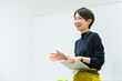 © One - 会議室でプレゼンをする30代日本人女性