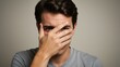 © M - A man covers his face, expressing concern and introspection.