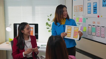 Wall Mural - asian businesswomen discussing and analyzing website design on a whiteboard with ux and ui concepts,