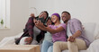 © ABCreative - A joyful, beautiful girl records a video for her friends with her phone, along with her parents and sister. They wave at the camera from their new, renovated apartment.