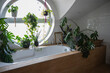 © Westend61 - Beautiful bathroom decorated with many home plants and a circular window