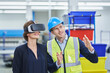 © Westend61 - Male supervisor explaining plan to female manager wearing VR glasses in factory