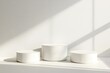 © Ikram - Simple white podiums in sunlight