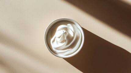 Aufkleber - Aerial view of white creamy yogurt swirls in a ceramic bowl set against a warm beige background enhancing texture and light