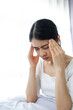 © Ton Photographer4289 - Young woman touching her temples with her hand because of severe headache due to stress or migraine. Health and mental health problem concept.