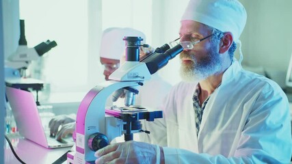 Wall Mural - experienced scientist adjusting microscope, conducting research in advanced laboratory, assisted by 