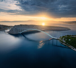 Wall Mural - aerial view of bridge and blue sea at colorful sunset. modern krk bridge island during golden hour, 