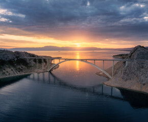 Wall Mural - aerial view of bridge and blue sea at colorful sunset. modern krk bridge island during golden hour, 