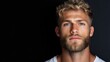 © SATRIANANGISAN - Close-up portrait of a light-skinned man with a serious expression, styled blonde hair and a short beard