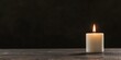 © xbzz - Single Lit Candle on a Dark Wooden Table Symbolizes Remembrance, Grief, and Hope