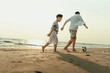 © Charnchai saeheng - Father and son play football happiness on the beach during vacation, travel, long weekend, summer or any other holiday. They are happy to spend time together.