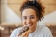 © Dusan Petkovic - Portrait of a happy girl sitting in fast food restaurant and eating doughnut.