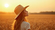 © Vitaliy - Young woman in straw hat enjoying sunset in wheat field, peaceful nature scene, summer countryside landscape, golden hour, rural lifestyle, relaxation, mindfulness, outdoor serenity, warm sunlight