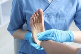 Doctor examining patient's foot in hospital, closeup