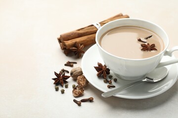 Wall Mural - aromatic masala tea in cup and spices on light grey table, closeup. space for text