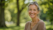 © f_bossa - Portrait headshot photo of diverse friendly people: A smiling woman with silver-streaked hair stands outdoors, bathed in sunlight, radiating warmth and positivity.