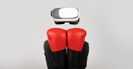 Poster - A user engages with virtual reality technology using a headset while wearing red boxing gloves. The setting features a minimalist background, emphasizing the immersive gadget experience.