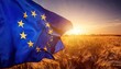 © GeorgV - EU Flag Waving in Windswept Wheat Field at Sunrise