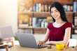 © Prostock-studio - Cheerful Asian Woman Working Remotely On Laptop In Cafe, Smiling At Camera, Young Korean Female Freelancer Using Computer And Drinking Coffee Or Tea At Table, Enjoying Online Job, Copy Space