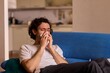 © Евгений Вершинин - A Young Man Experiencing Discomfort While Enjoying a Relaxing Day at Home Comfortably