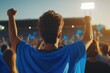 © VolumeThings - Fans in blue scarves enthusiastically support their team in a packed evening stadium