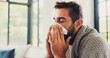 © BuyOutFelix01/peopleimages.com - Sick, man and sneezing with blanket in home for flu symptoms, fever and respiratory disease on sofa. Illness, person and virus infection in living room with bacteria, blowing nose and sinus allergy
