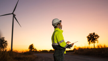 Poster - Engineer man working with tablet at windmill farm Generating electricity clean energy. Wind turbine farm generator by alternative green energy.