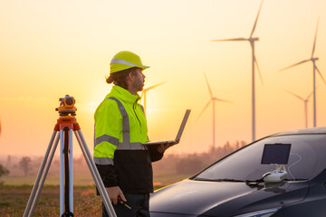 Aufkleber - Engineer working on laptop in front of wind turbines for checking wind turbines of the field during beautiful sunset. Alternative energy concept.